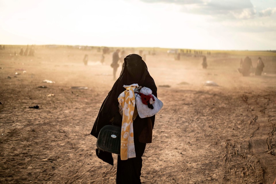 A woman evacuated from the Islamic State (IS) group’s embattled holdout of Baghouz arrives at a screening area held by the US-backed Kurdish-led Syrian Democratic Forces (SDF)