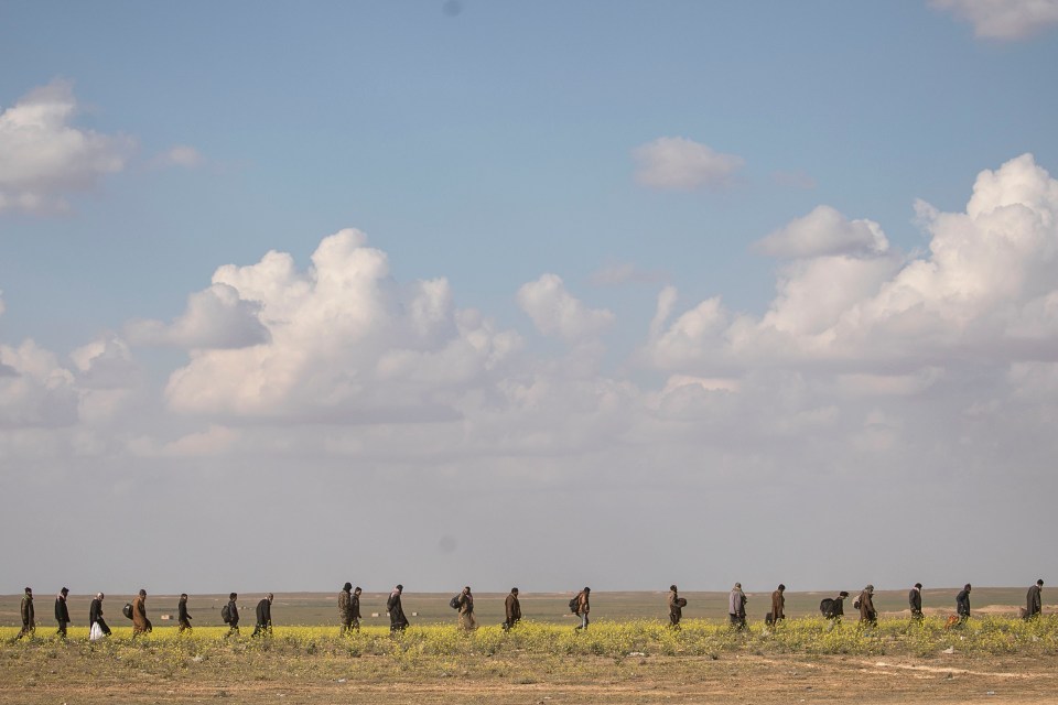 Civilians walk together near Baghouz, Deir Al Zor province, Syria