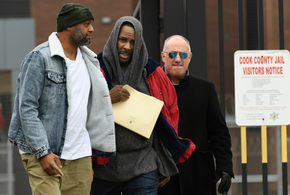  R Kelly covers his head under a blanket as he walks free from jail in Chicago on Saturday