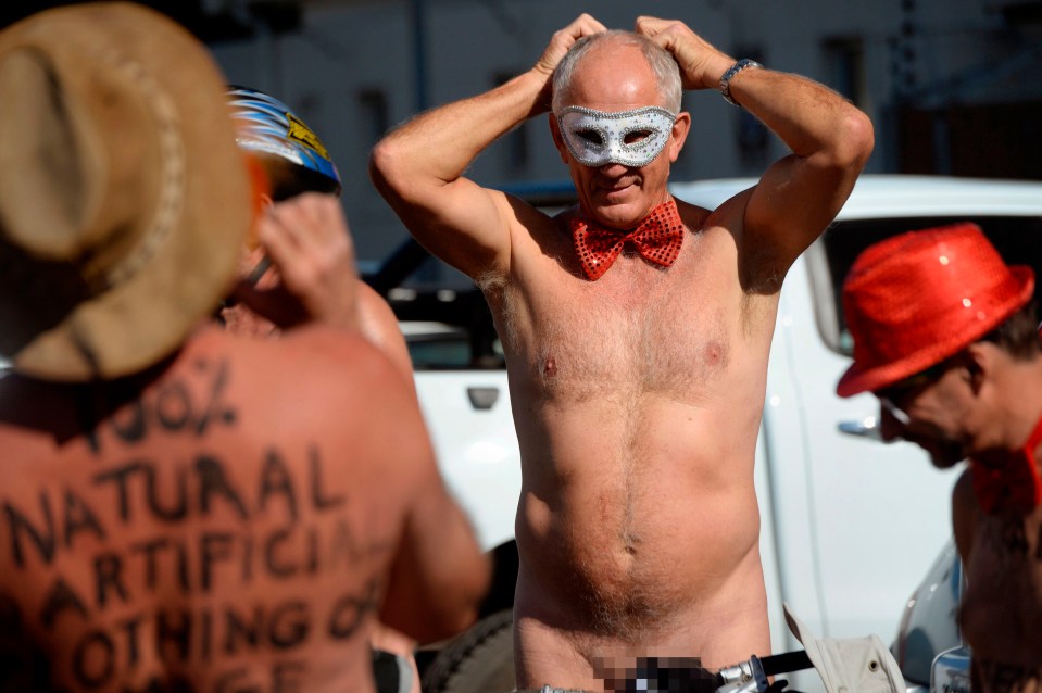 This man wears a glittered bow tie and silver face mask in Cape Town for the Naked Bike Ride