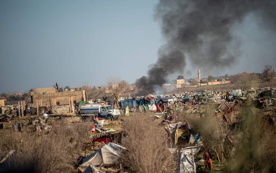  Smoke rises from a makeshift camp for ISIS members and their families in Baghouz,. Thousands of people, mostly women and children, have fled over the past days but it's feared several brainwashed people remain inside