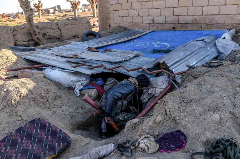  A fighter with the Syrian Democratic Forces (SDF) inspects makeshift shelter dug in a trench at a makeshift camp for Islamic State members and their families in the town of Baghouz