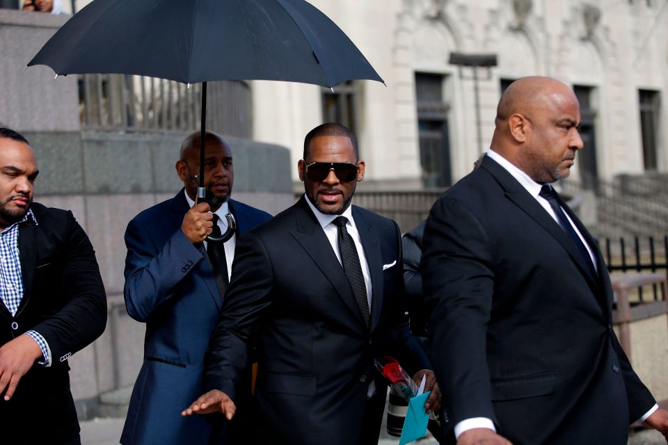  The singer waves as he holds a card and a rose he received from fans while leaving court on March 22