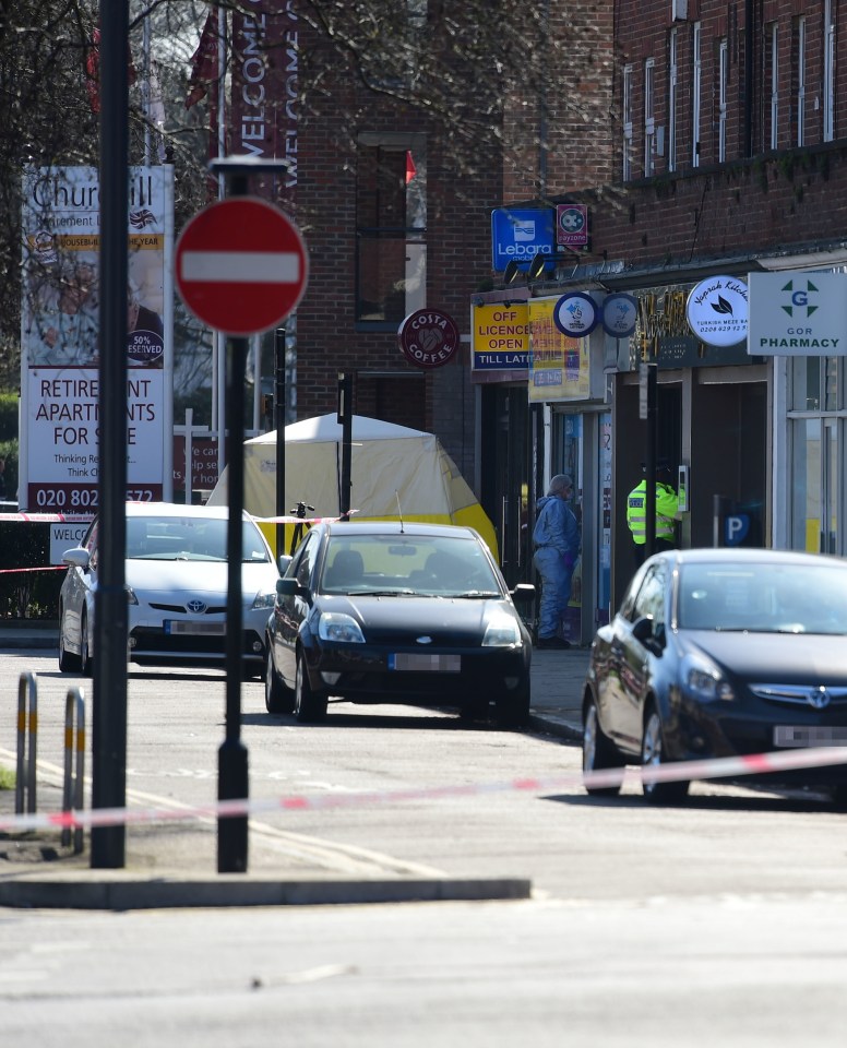 A forensics investigator stands by a newsagent in Marsh Road, Pinner