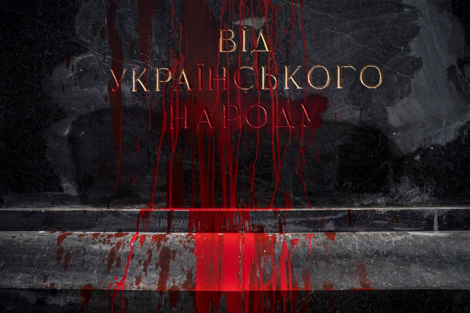 Red paint thrown by activists drips from a monument to a Red Army general who died in WWII