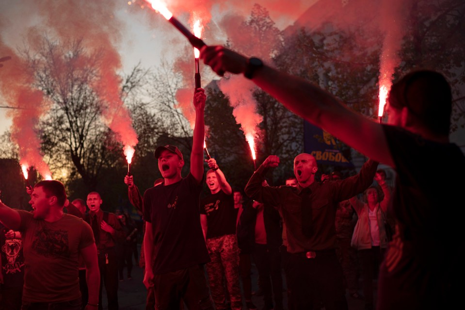 Members of the nationalist group Sokil, the youth wing of the Svoboda party, chant and hold flares during a concert in Kiev