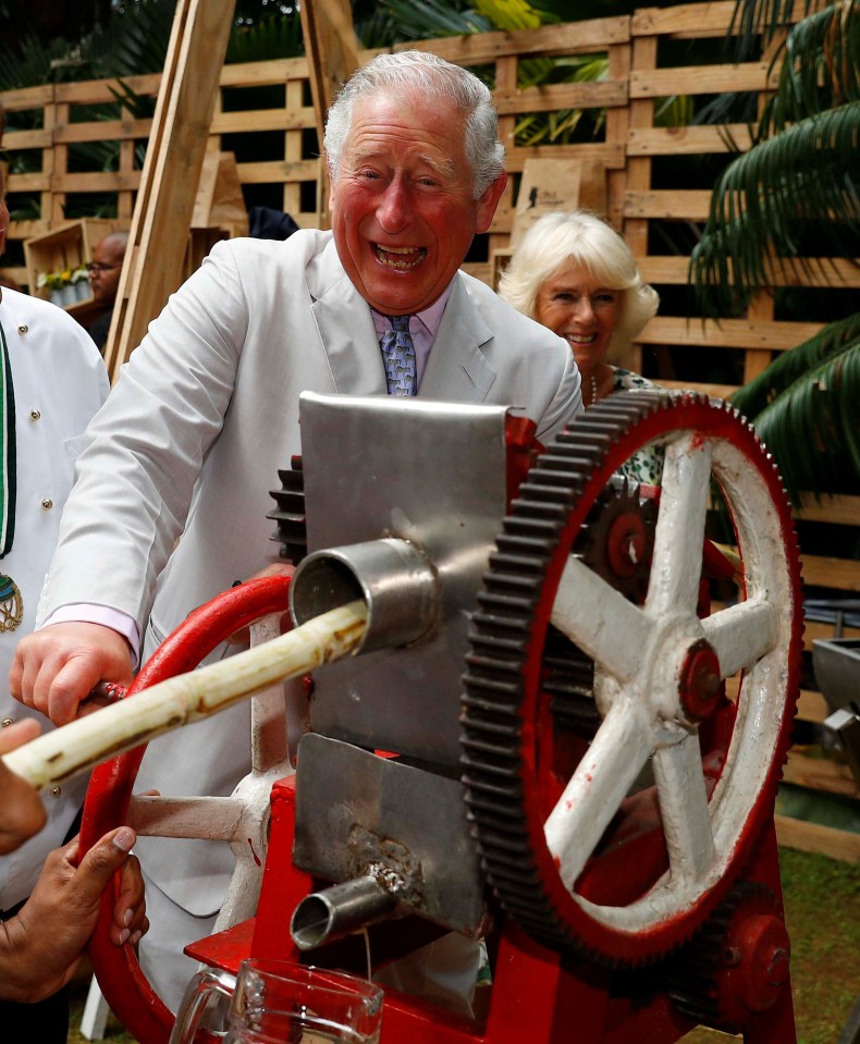  Prince Charles presses sugar cane to make juice during a visit to a paladar