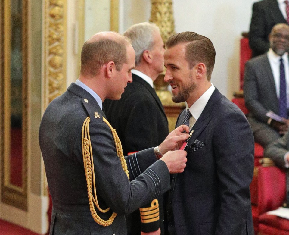 Prince William pins an MBE onto Harry Kane's suit at Buckingham Palace