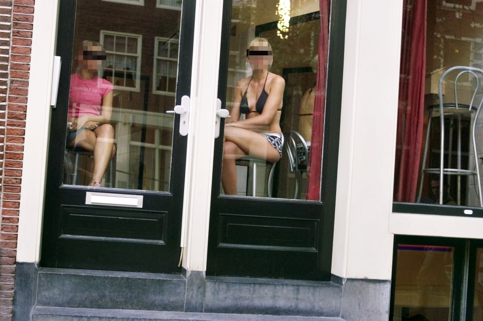  Two prostitutes behind windows in Red Light District, Amsterdam