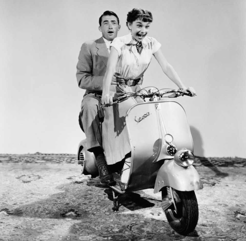 Gregory Peck and Audrey Hepburn practice a moped scene for the 1953 comedic romance Roman Holiday