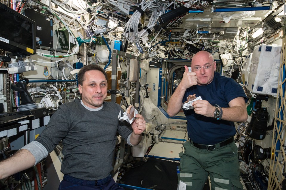  NASA astronaut Scott Kelly gives a thumbs up on the quality of his snack alongside Russian cosmonaut Mikhail Kornienko in this photo from April 2015