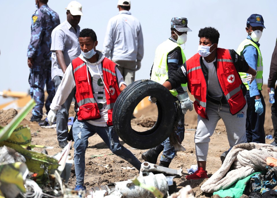  Emergency crew remove a tyre from the wreckage of the jet