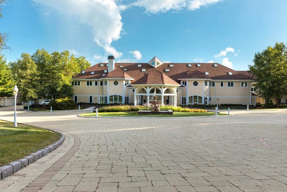  A grand water feature sits at the centre of the paved drive in front of the house