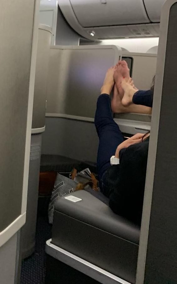 The woman was caught stroking her fellow travellers feet while sitting in first class