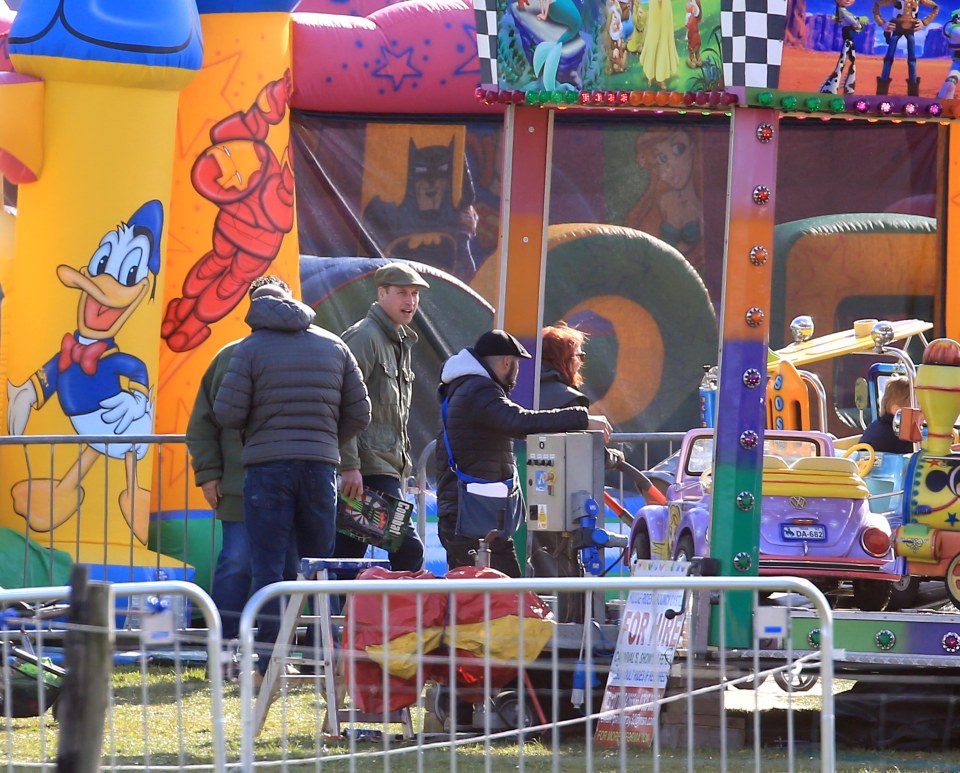 Prince William looks on while at one of the carnival rides