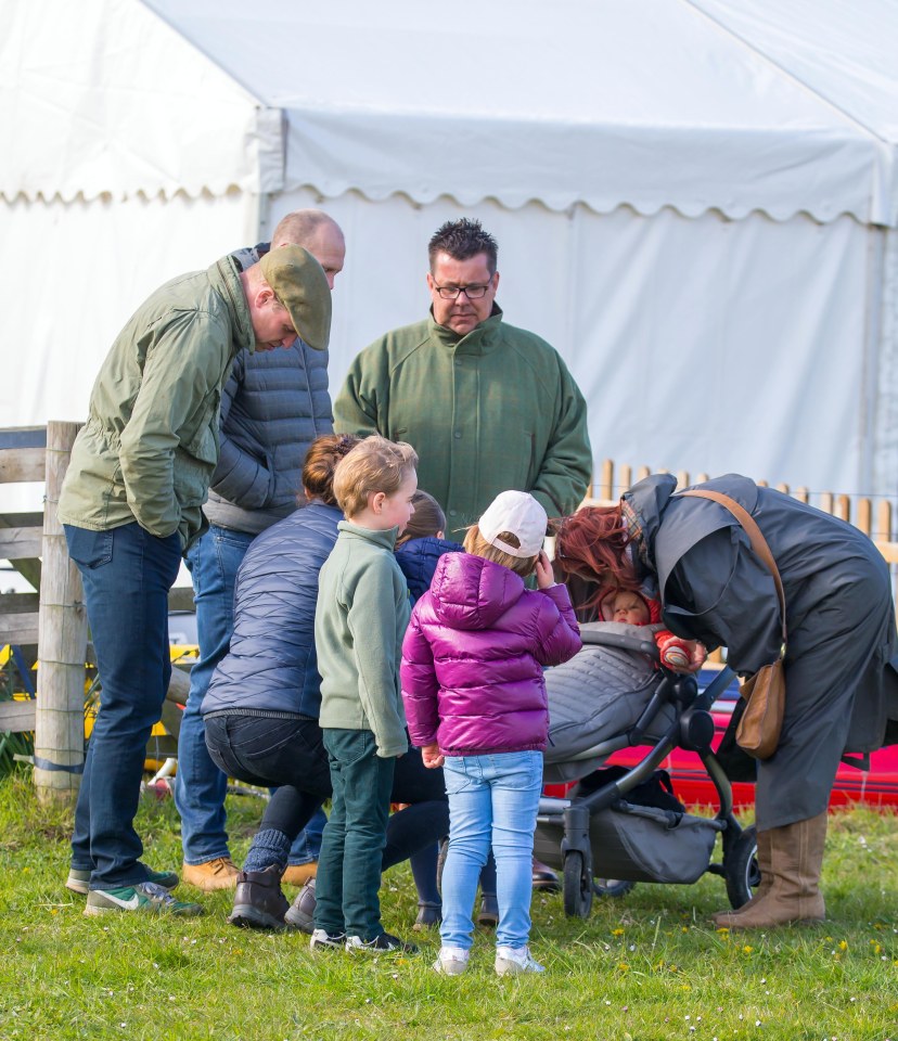 The two families appear to coo over nine-month-old Lena Tindall in the pram