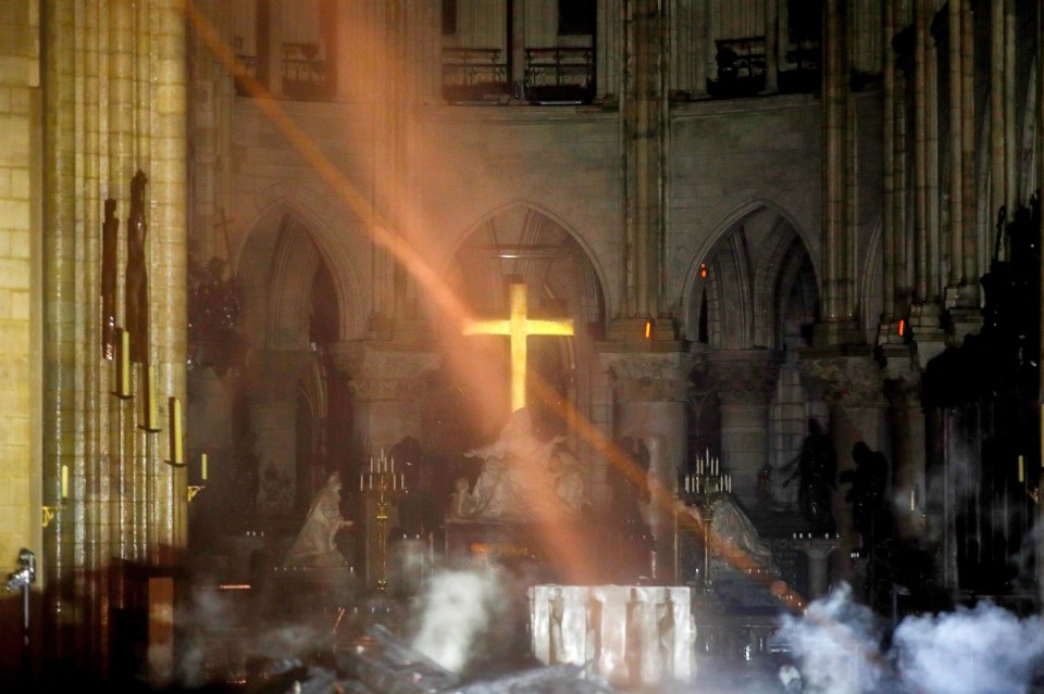  Inside the cathedral, smoke could be seen rising from the smouldering remains of the Notre Dame's roof and spire after a fire broke out on April 15