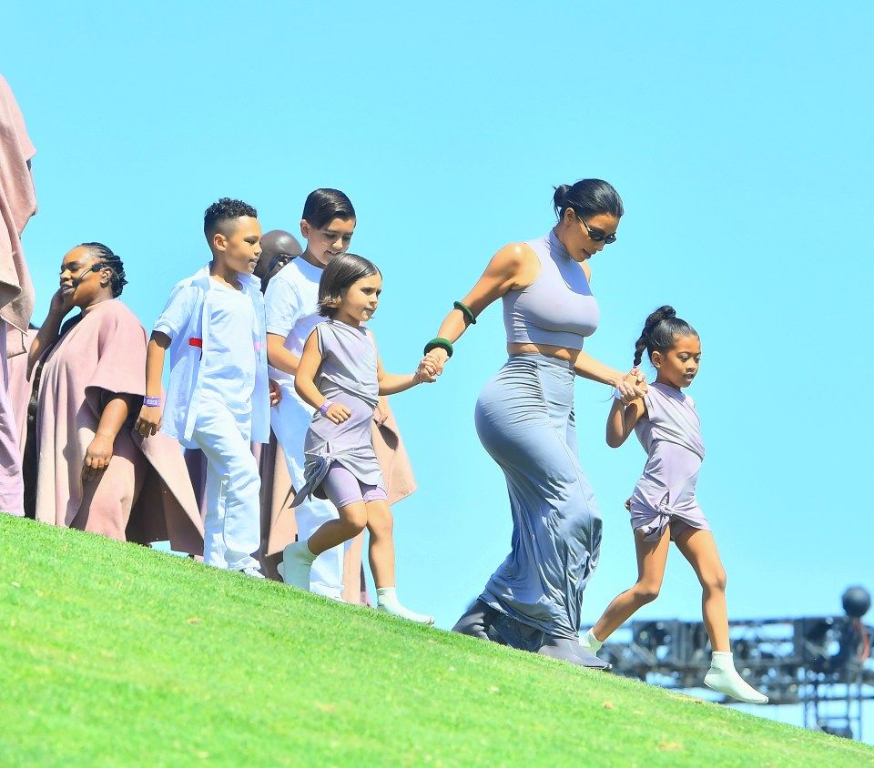  Kim was spotted holding daughter North West, and as well as her nieces and nephews as she ran upto the hilltop where her famous rapper husband was performing