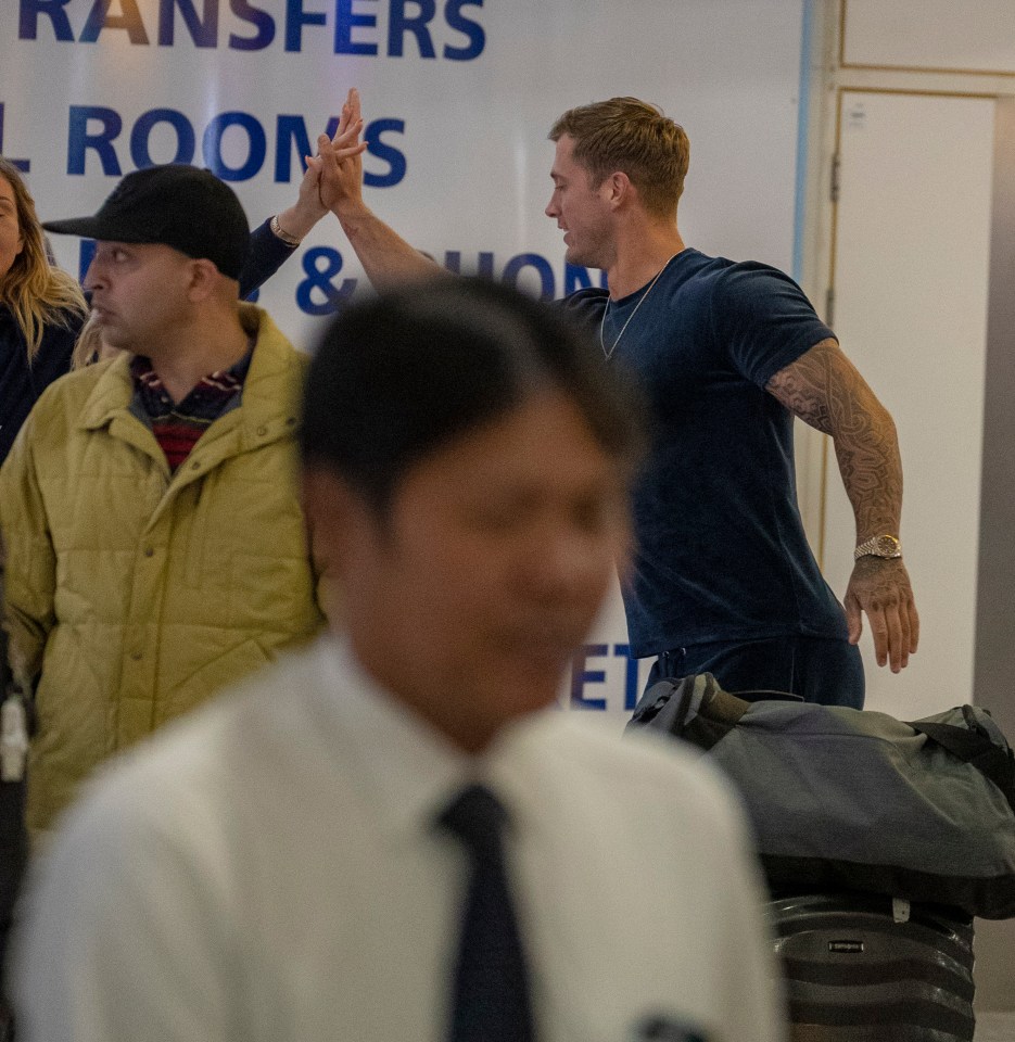  Steph and Dan high five each other goodbye at the airport