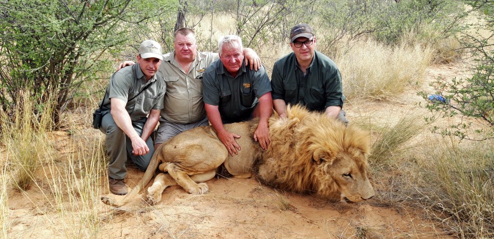  Hunters pose with Simba, the lion who gave Lord Ashcroft's undercover investigation the name Operation Simba