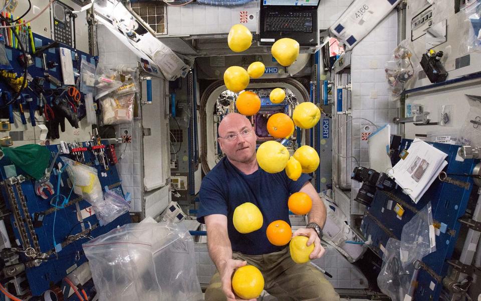  NASA astronaut Scott Kelly juggles some fruit after a food delivery to the International Space Station