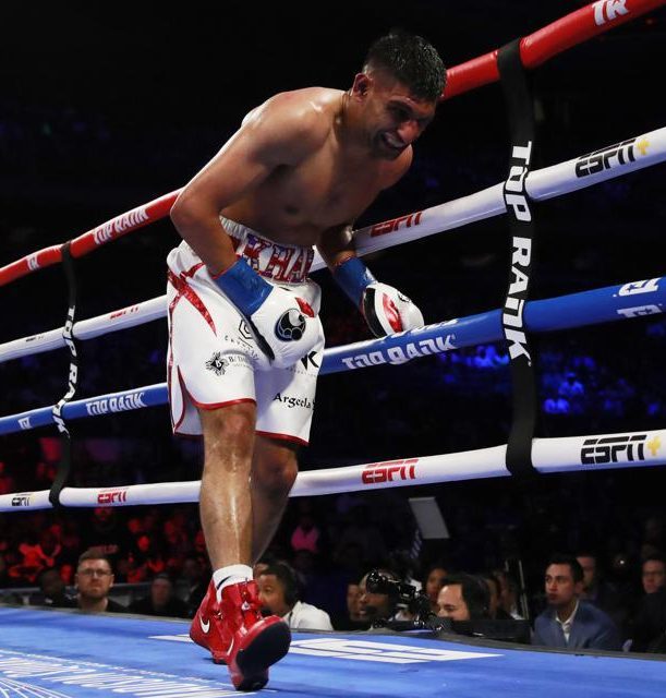 Amir Khan reeled in pain in a fight ending that infuriated the 10,000 crowd 