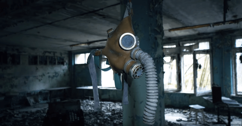  A haunting image captures a gas mask hanging from the ceiling