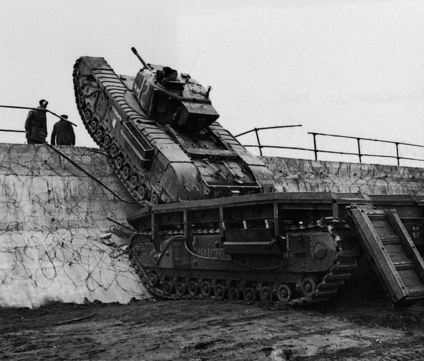  A Churchill tank crosses a seawall in England using an ARK – Armoured Ramp Carrier bridge layer