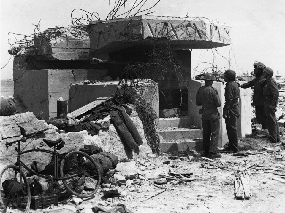  British infantry and airborne troops examine a German anti-tank gun position after the landings