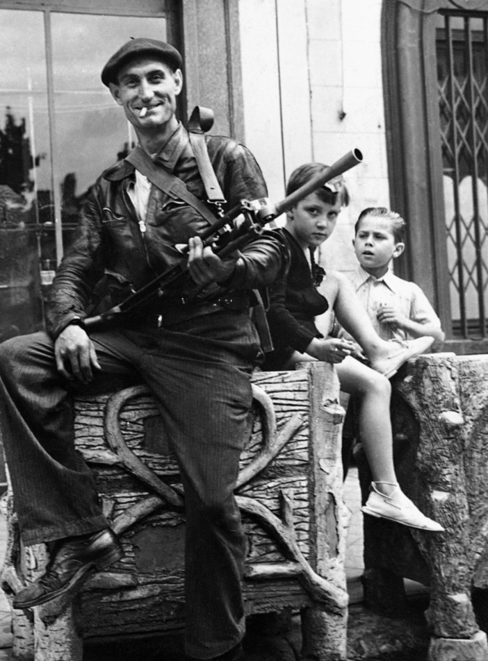  Cradling his Bren Light Machine Gun, a member of the French Resistance strikes a pose after D-Day