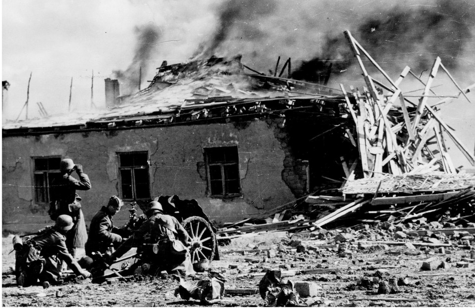  German soldiers attempting to load their weapon as Allied Forces bear down on their position