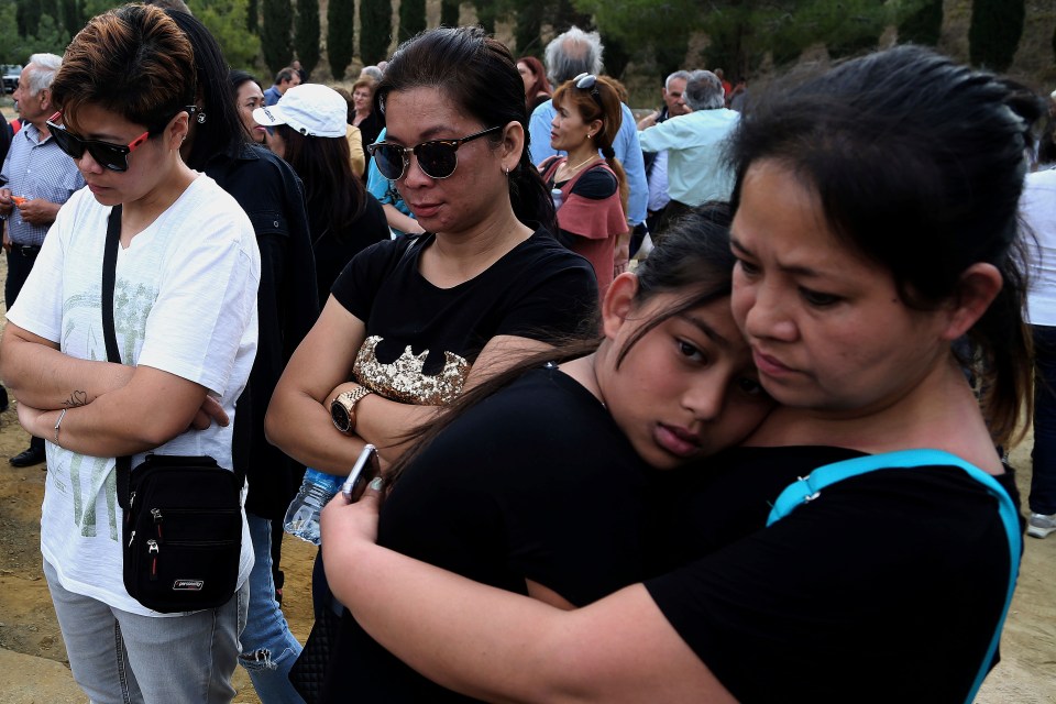  People attend a memorial for victims at the mineshaft where two female bodies were found near the village