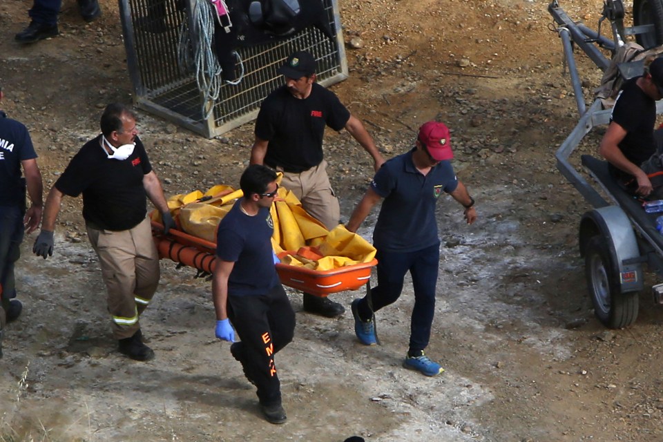  Members of the Cyprus special disaster response unit carry a suitcase after it was retrieved from a man-made lake near the village of Mitsero outside of the capital Nicosia on Sunday, May 5