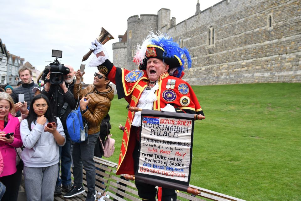  The crier rings his bell as tourists capture the moment on their phones