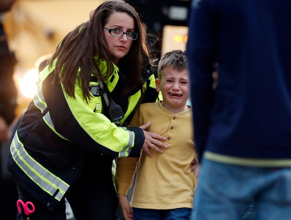  Officials guide students off a bus and into a recreation centre where they were reunited with their parents after a shooting at a Denver middle school in Colorado