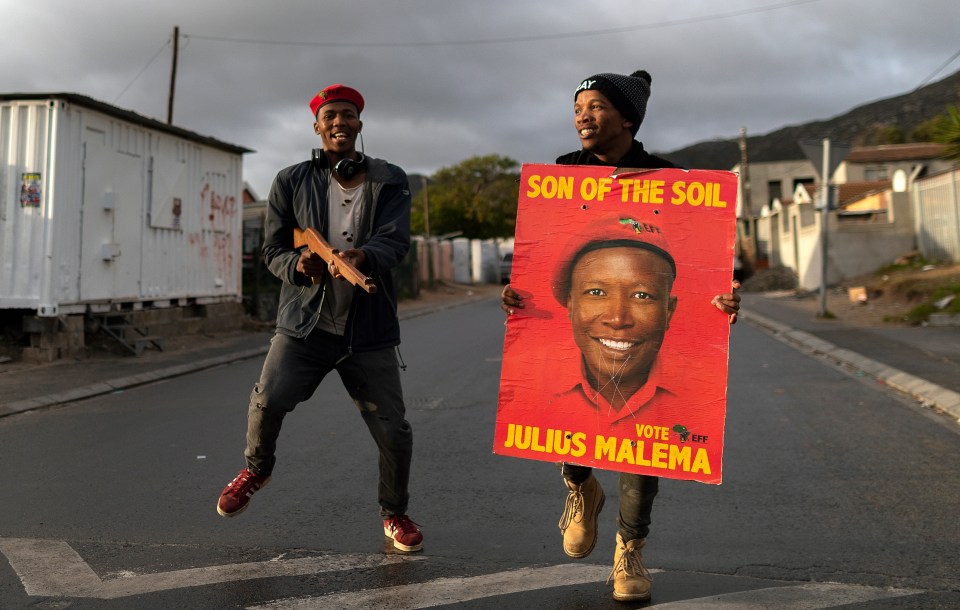  Supporters of the Economic Freedom Fighters, a South African far left political party, dance outside a polling station in Masiphumelele, Cape Town, South Africa on May 8. Millions of South Africans head to the polls as the country holds its 5th general election