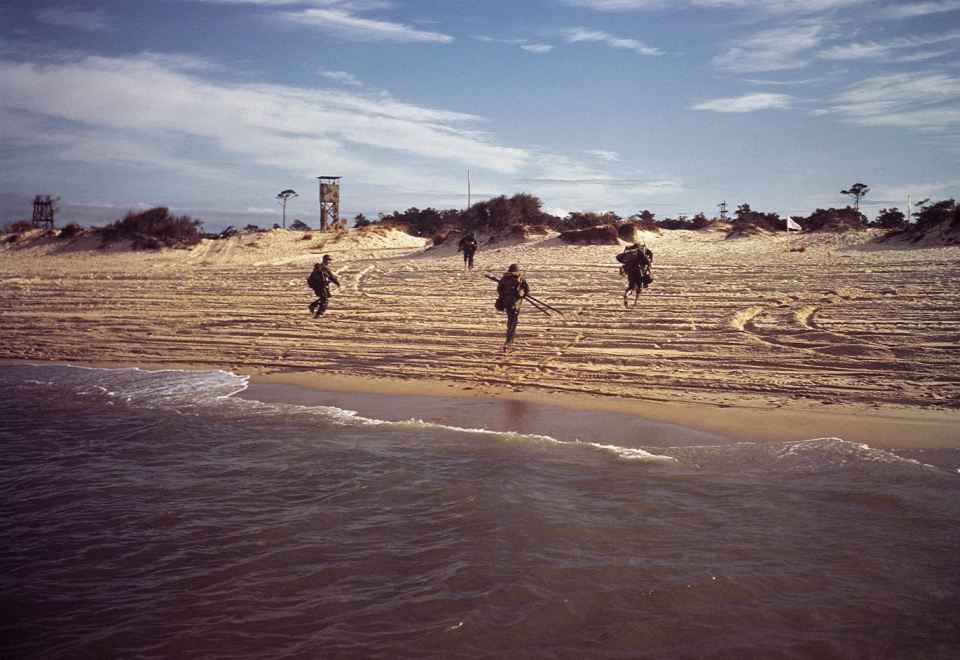  US soldiers dash ashore from a landing craft in a training area in southern England