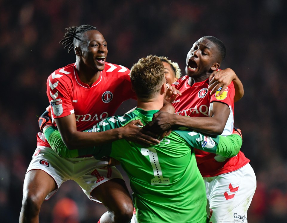  Charlton keeper Dillon Phillips is mobbed after he helped send them through on penalties against Doncaster