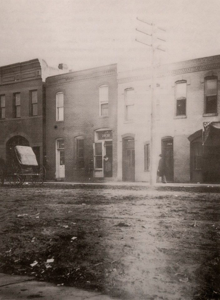  A potential male client walks down Market Street in Denver, as a prostitute hangs from her doorway (no 2032), during the 1890s. The street was a notorious area of Denver known simply as The Row