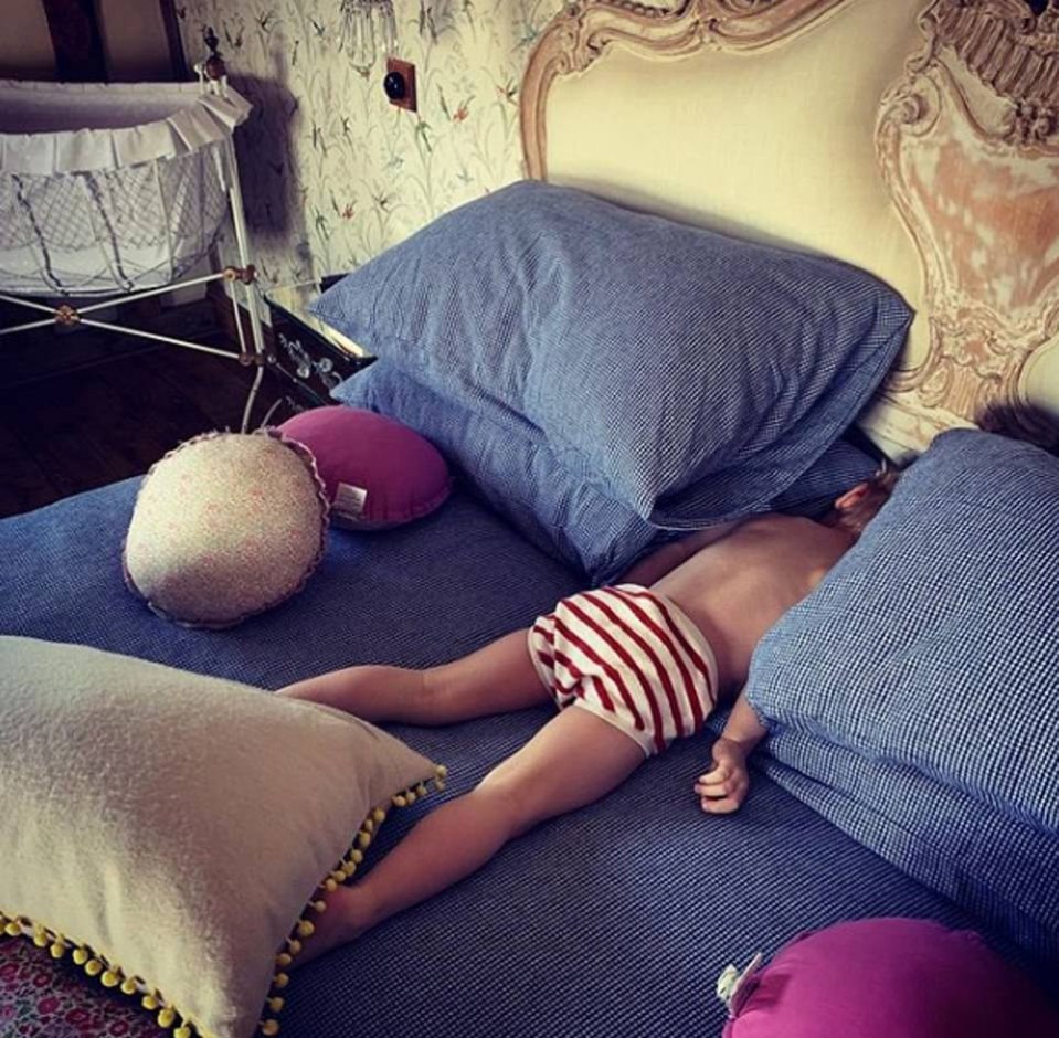  Little River seen sleeping between two piles of pillows on one of the house's comfy beds