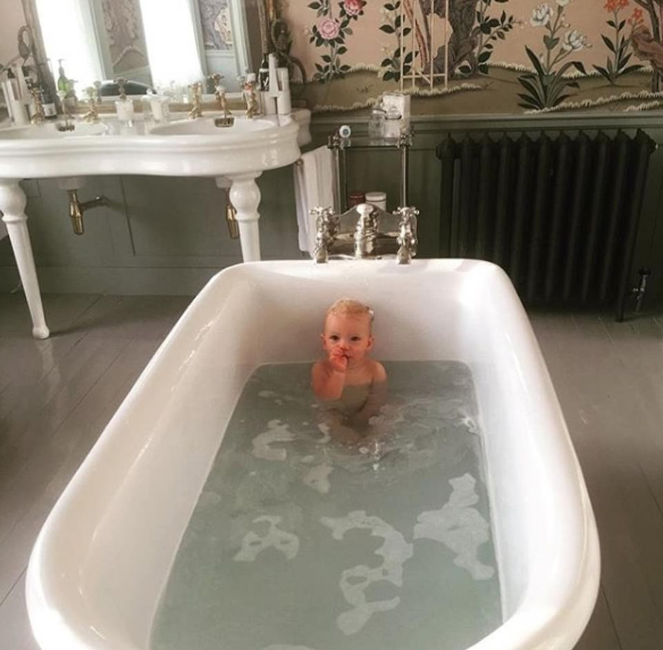  A free-standing bathtub sits in the middle of a plush tiled bathroom