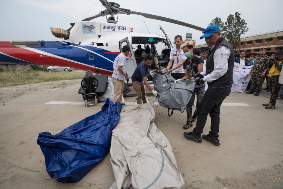  Nepalese trekking staff remove the bodies of dead Everest climbers after they were recovered from the mountain last week