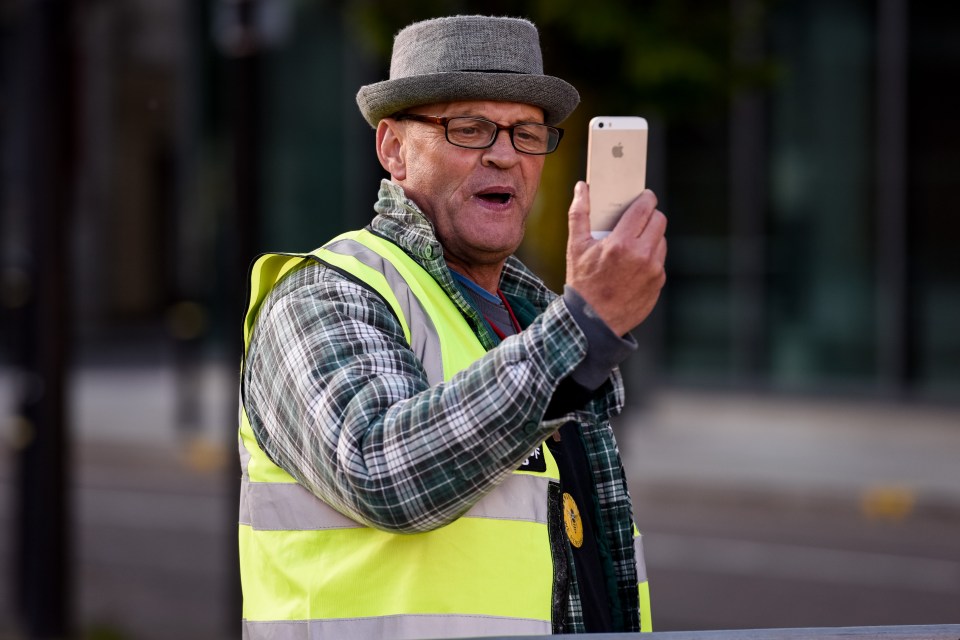  A pro-Robinson supporter wears a yellow vest as he films protests in Manchester