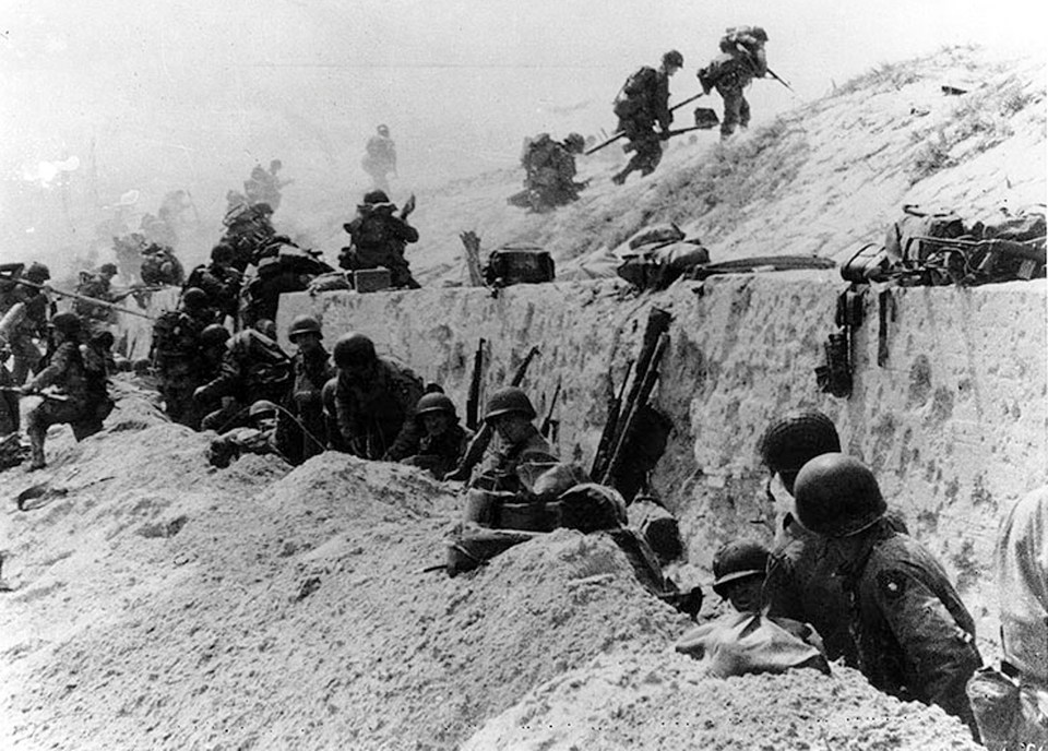  US Army soldiers of the 8th Infantry Regiment, 4th Infantry Division, move out over the seawall on Utah Beach