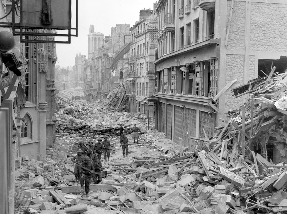  Canadian troops patrol along the destroyed Rue Saint-Pierre after German forces were dislodged from Caen in July 1944