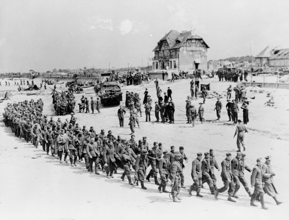  German prisoners-of-war march along Juno Beach landing area to a ship taking them to England, after they were captured by Canadian troops at Bernieres Sur Mer, France on June 6, 1944