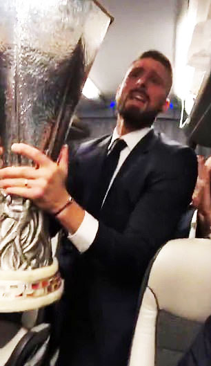  Olivier Giroud proudly holds aloft the Europa League trophy on the party bus