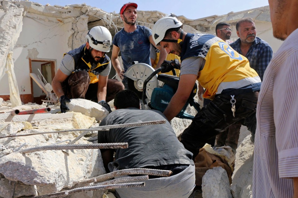  Volunteers from the White Helmets work to free those trapped beneath the rubble