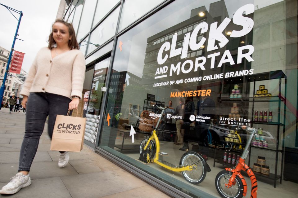  A woman carries a 'Clicks and Mortar' bag at the launch of the first shop in Manchester