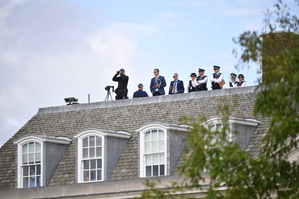  Security on the roof of Winfield House watch over the President and his team